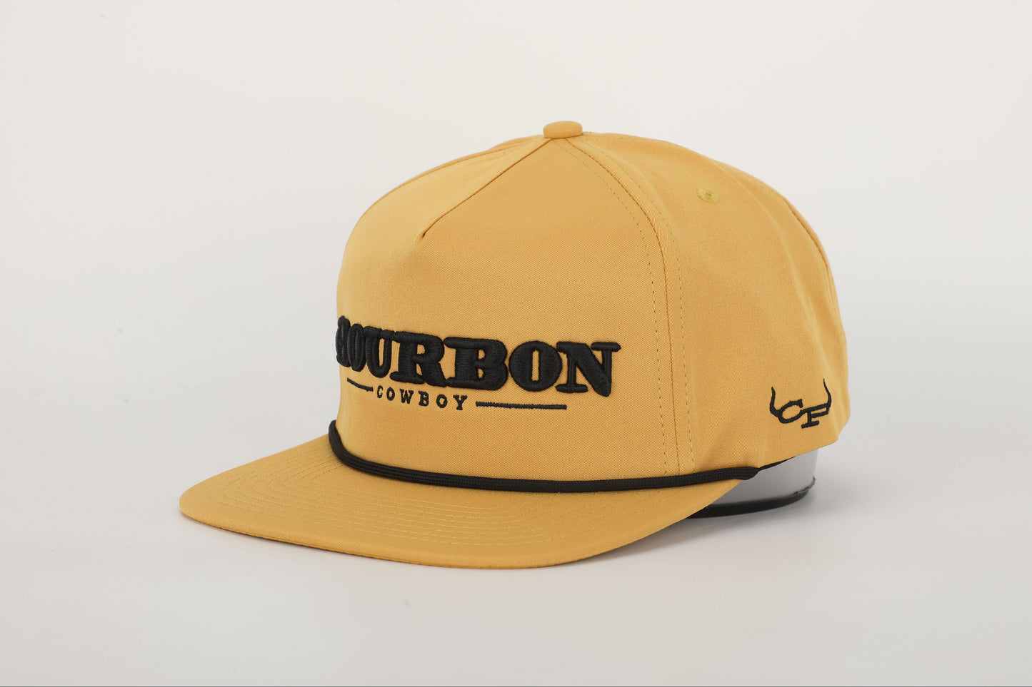 A mustard yellow snapback hat with 'BOURBON COWBOY' embroidered on the front. Angled View