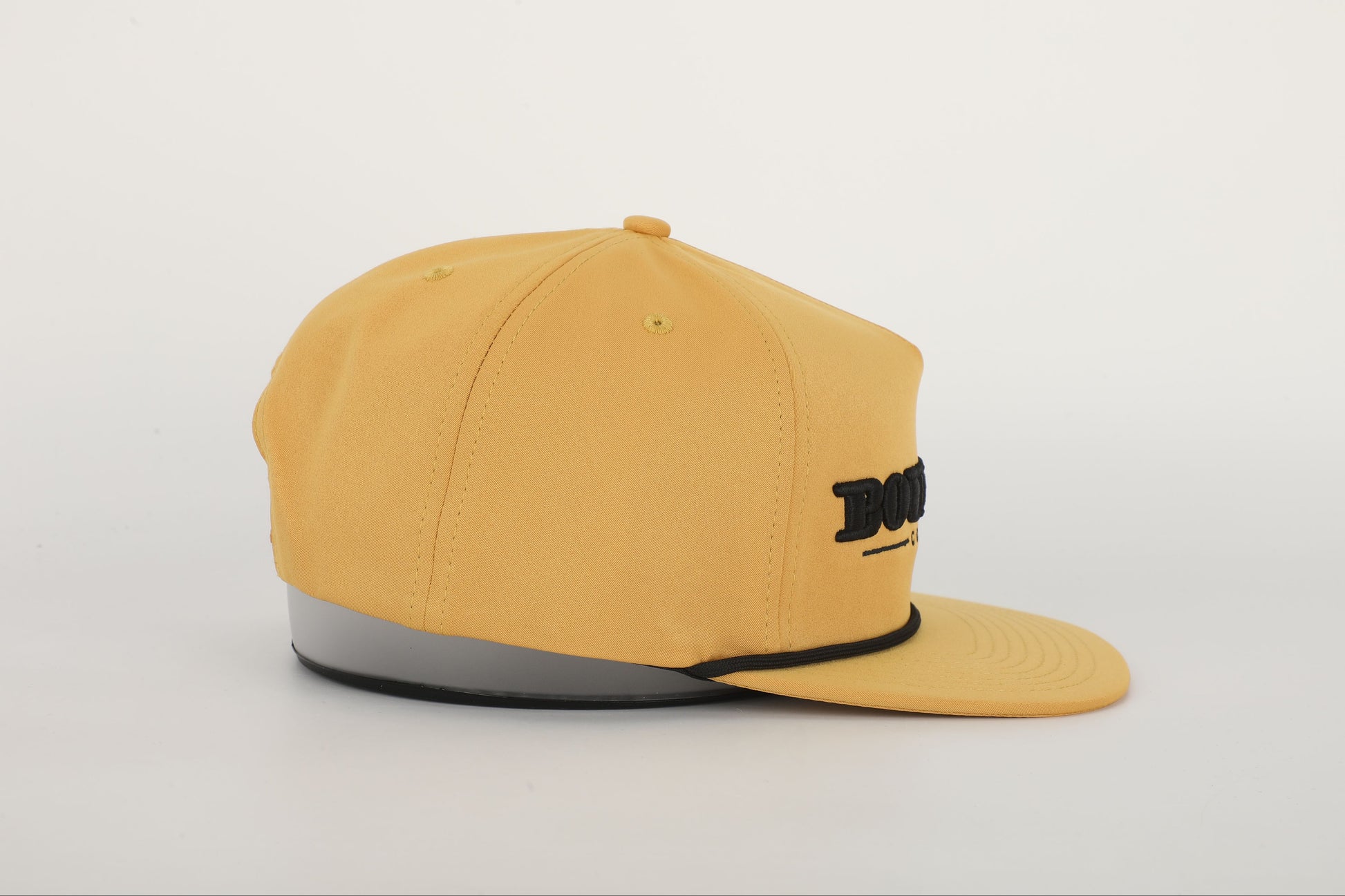 A mustard yellow snapback hat with 'BOURBON COWBOY' embroidered on the front. Left Side View