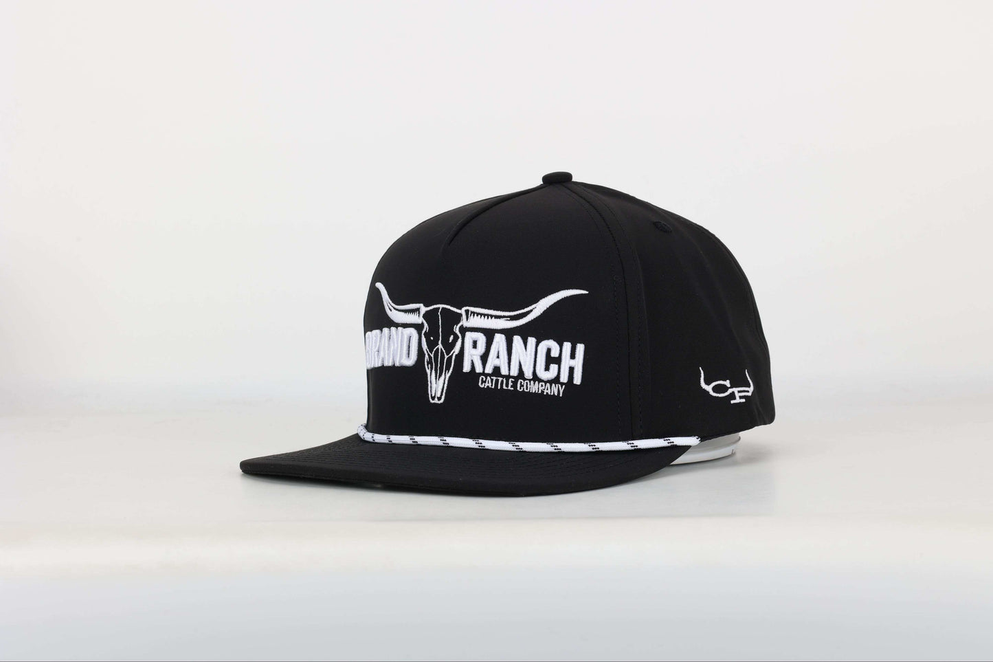 Black cap with a embroidered logo of a longhorn with texts that says 'BRAND RANCH' in white bold 3d embroidery. Angled View