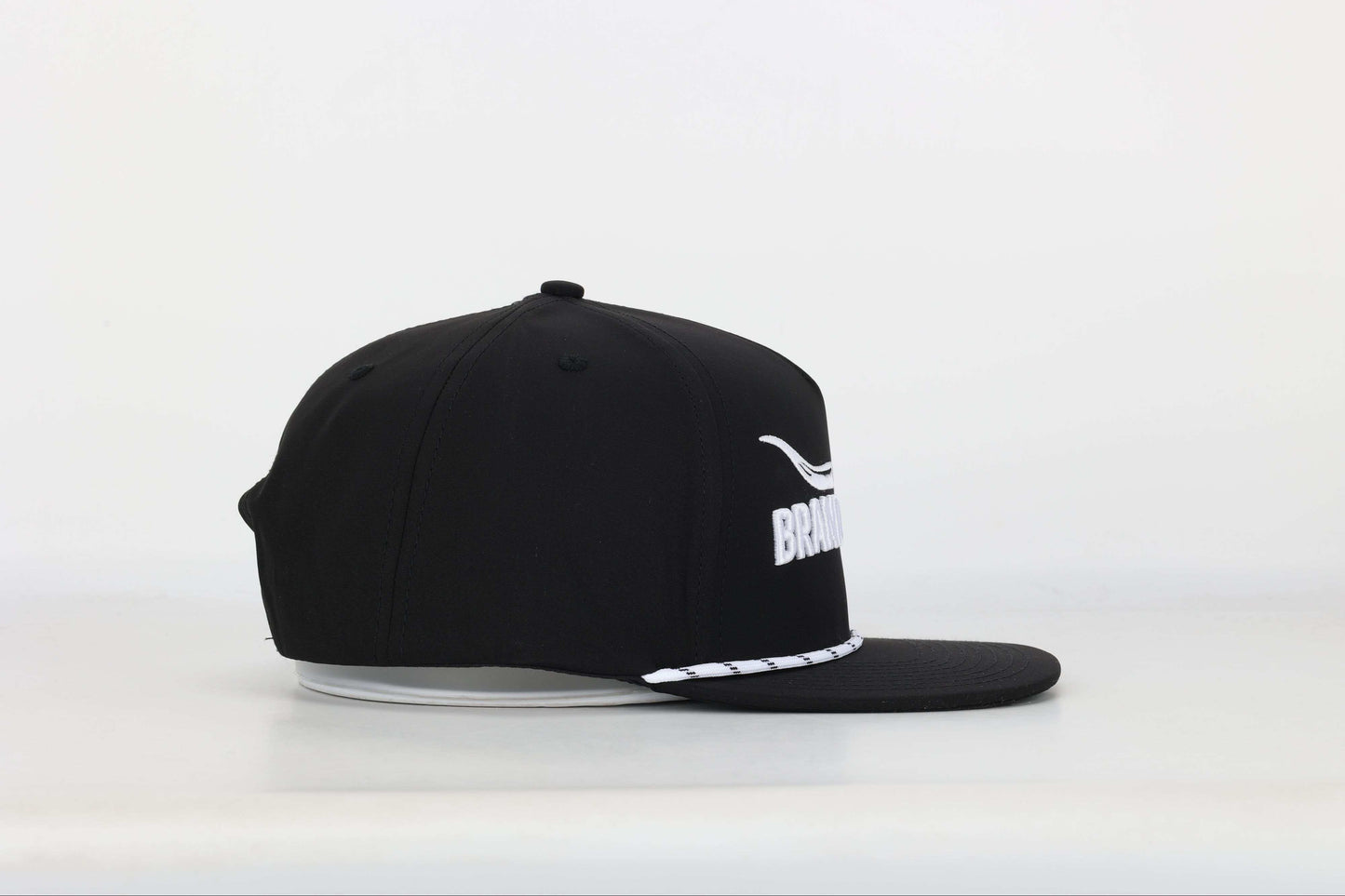Black cap with a embroidered logo of a longhorn with texts that says 'BRAND RANCH' in white bold 3d embroidery. Left Side View