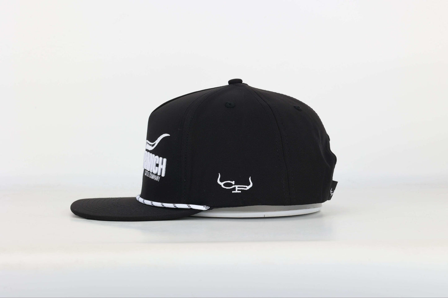 Black cap with a embroidered logo of a longhorn with texts that says 'BRAND RANCH' in white bold 3d embroidery. Right Side View