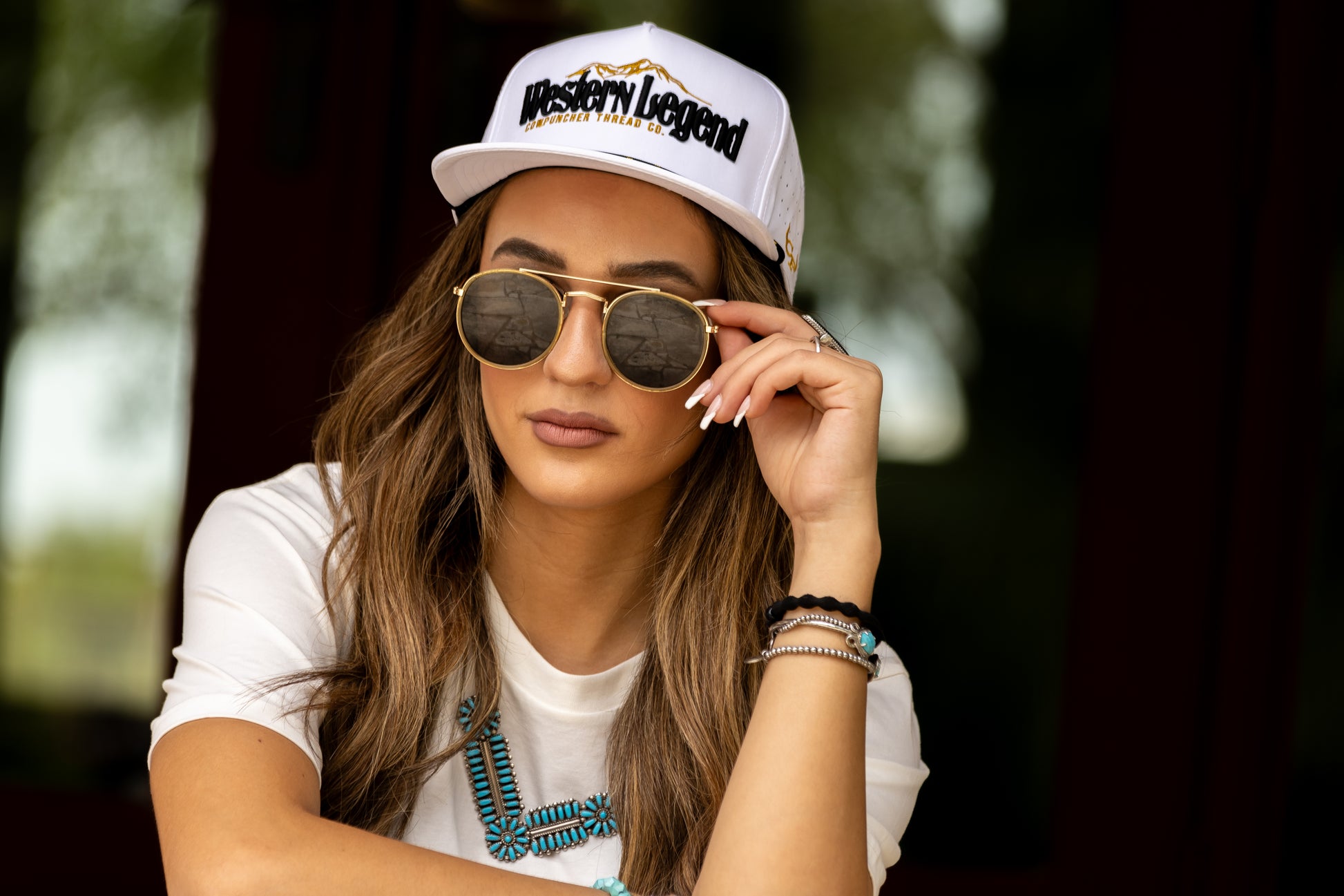 Woman wearing a white snapback cap . 'Western Legend' In Black an Gold embroidery