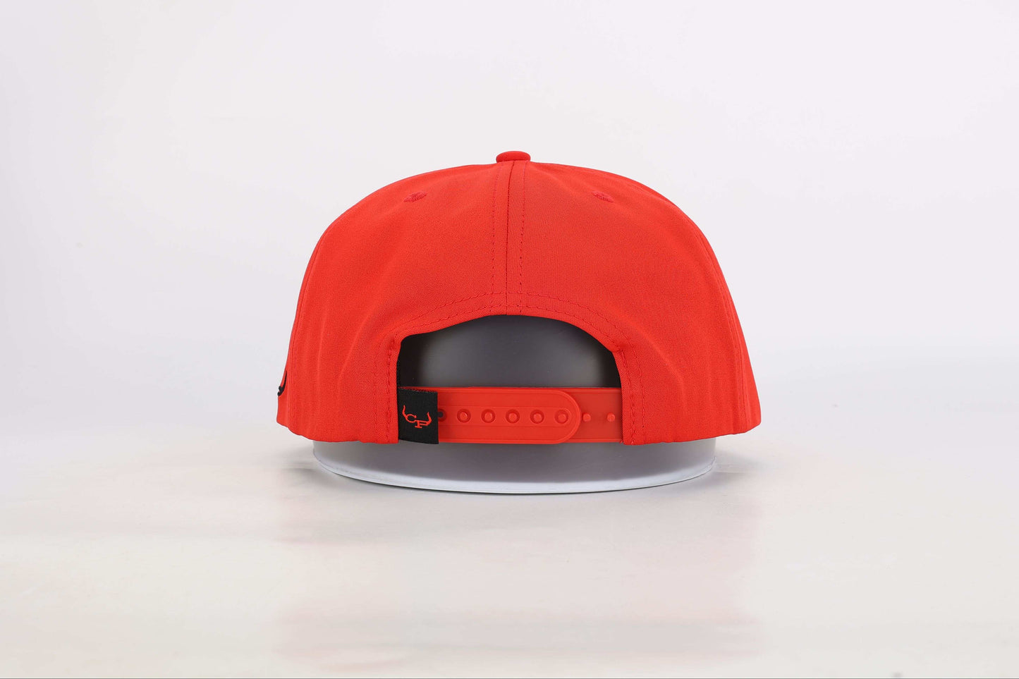 Red snapback cap with a woven patch that reads 'Real Cowboy Shit'. Back View