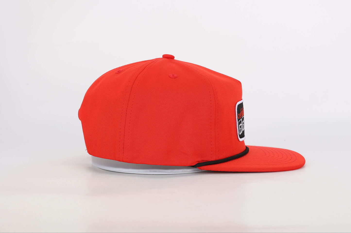 Red snapback cap with a woven patch that reads 'Real Cowboy Shit'. Left Side View