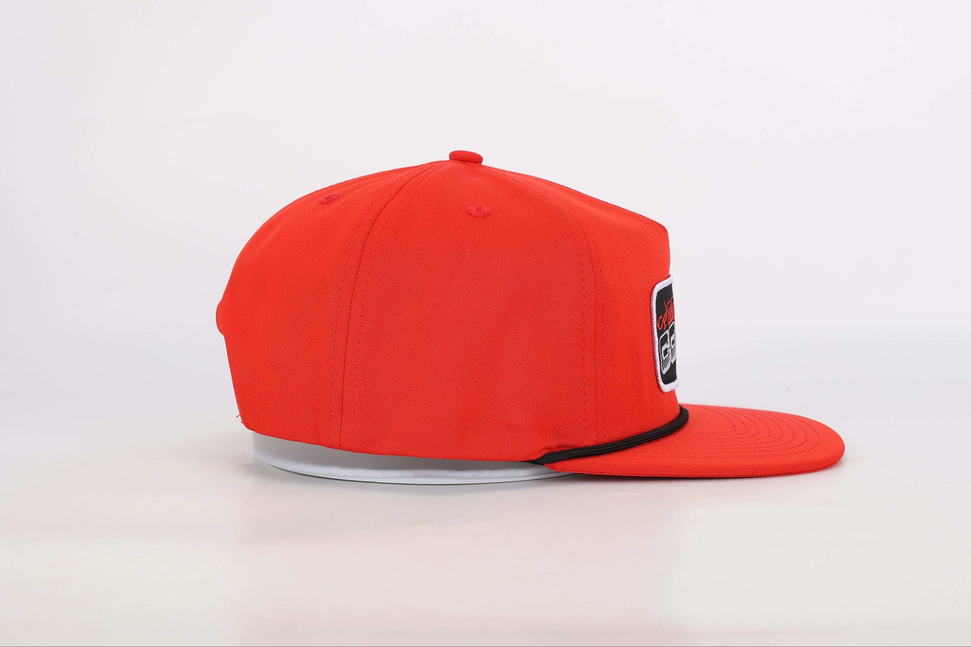 Red snapback cap with a woven patch that reads 'Real Cowboy Shit'. Left Side View