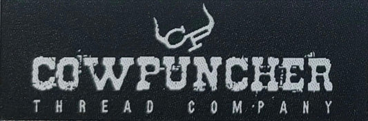 A black woven hat patch with white text and logo that reads 'COWPUNCHER THREAD COMPANY'.
