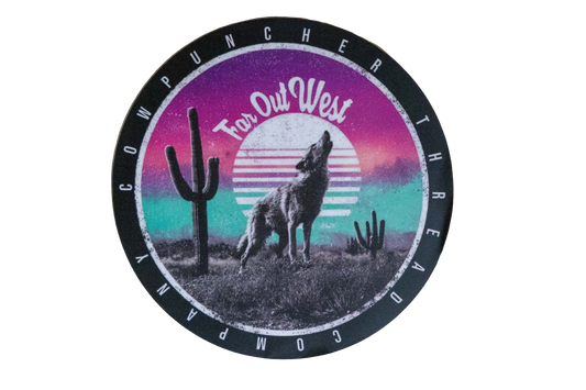 Round sticker with a coyote in the desert with cactus, with a purple and blue sunset design in the background