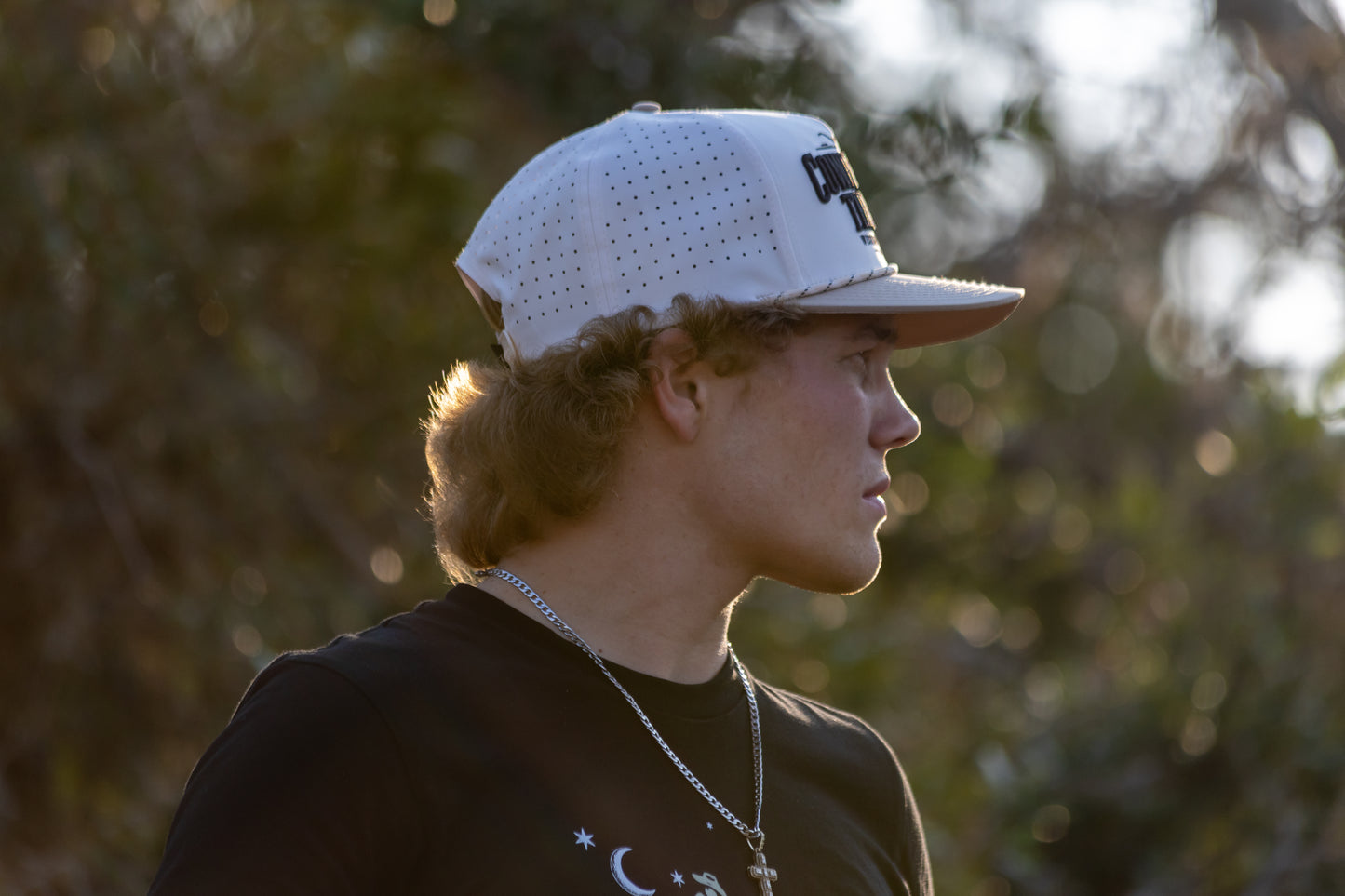 Gavan Hauck wearing a white Cattle Baron snapback cap with a logo outdoors.
