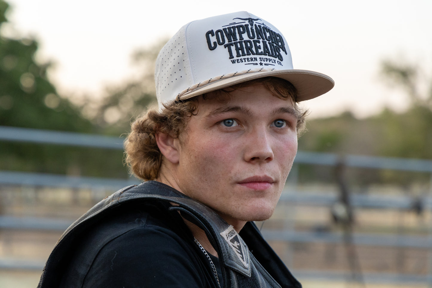 Gavan Hauck wearing a beige cap with Cowpuncher Thread Co. branding, outdoors