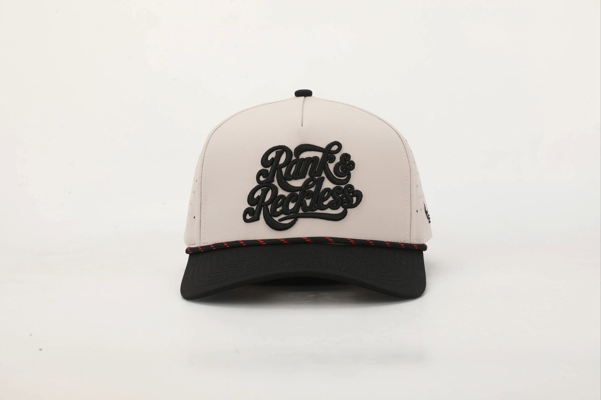 Beige and Black cap with 'Rank & Reckless' logo on the front with a Black and Red rope. Front View.