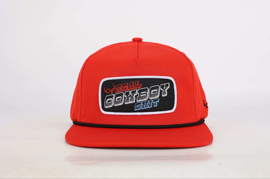 Red snapback cap with a woven patch that reads 'Real Cowboy Shit'. Front View